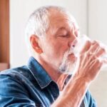 Un homme en train de boire un verre d'eau